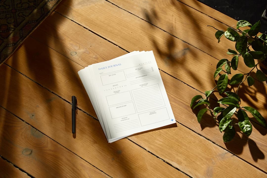 A cedar desk with a journal and notebook in morning light.